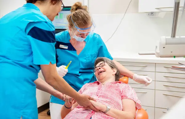 Tandarts en assistent behandelen een cliënt met een verstandelijke beperking.